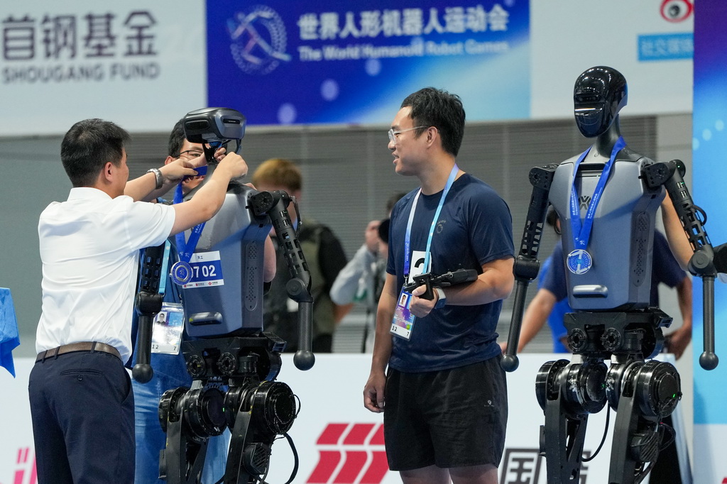 8月17日，頒獎嘉賓在4x100米接力決賽頒獎儀式上為獲得亞軍的天工隊的人形機器人頒發獎牌。