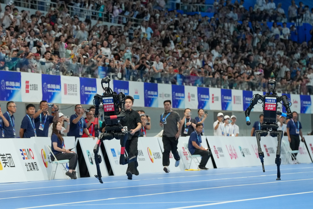 8月17日，在世界人形機器人運動會100米決賽中，來自高羿科技隊（右）和靈翌科技隊（左）的人形機器人在比賽中。