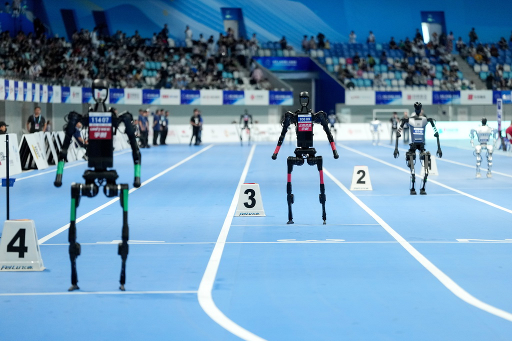 8月17日，在世界人形機器人運動會4x100米接力決賽中，來自行者泰山隊（右一）、天工隊（右二）、靈翌科技隊（左二）和宇樹科技隊的人形機器人等待比賽開始。