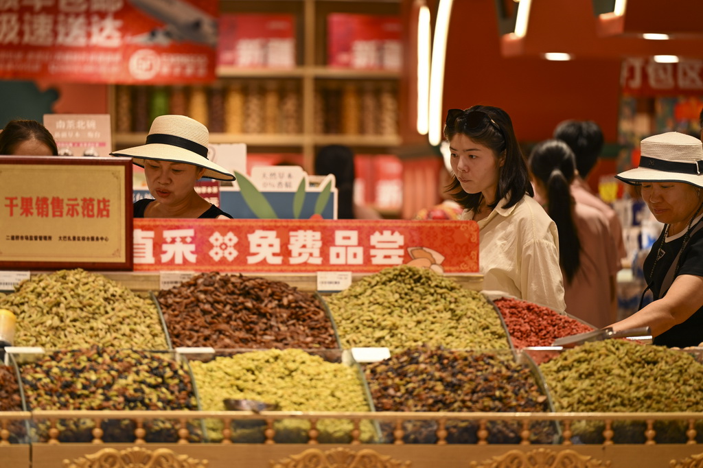 8月21日，游客在烏魯木齊大巴扎步行街選購干果。