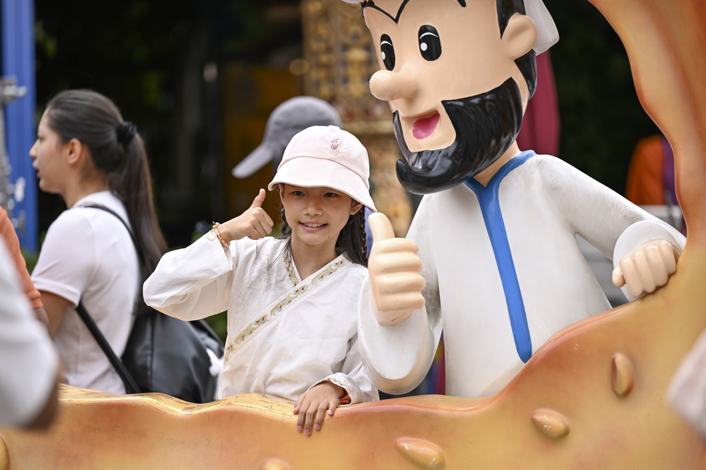 8月21日，小游客在烏魯木齊大巴扎步行街拍照留影。