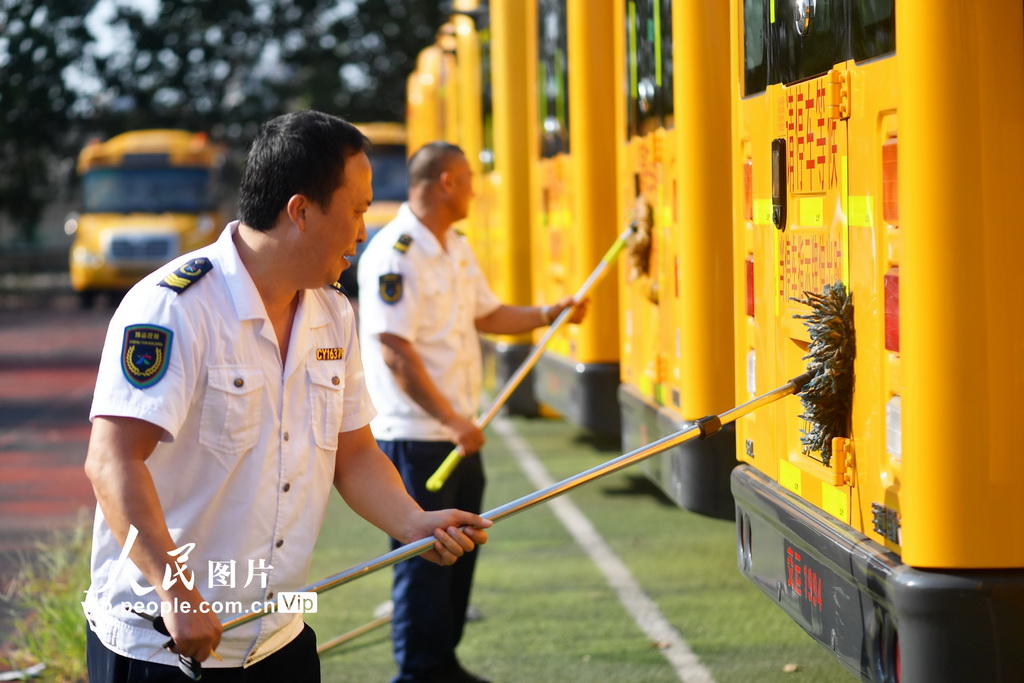 2025年8月22日，在山東省青島市城陽區上馬街道教育服務中心，技術人員和駕駛員在對校車進行維護。