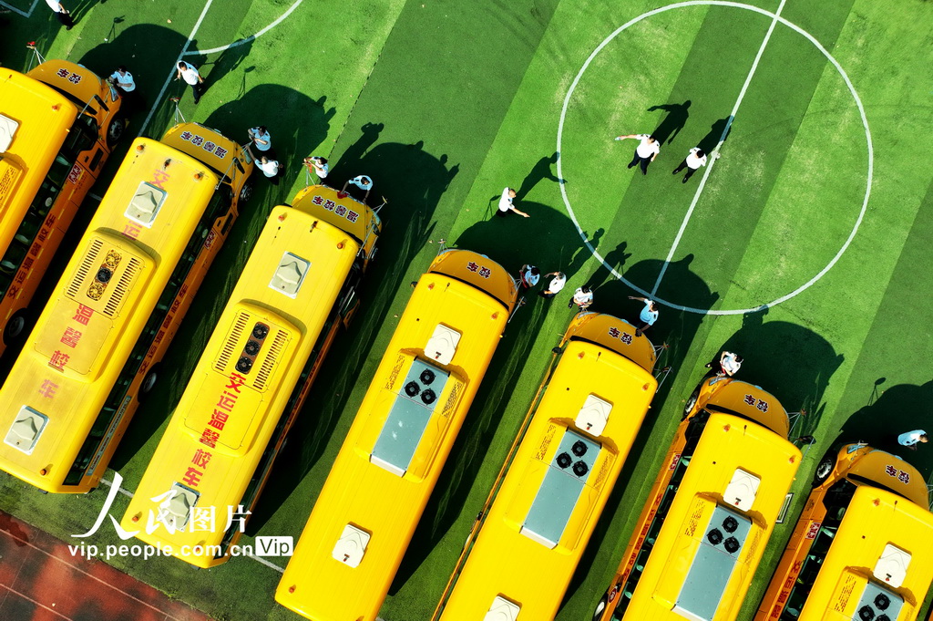 2025年8月22日，在山東省青島市城陽區上馬街道教育服務中心，技術人員和駕駛員在對校車進行維護。