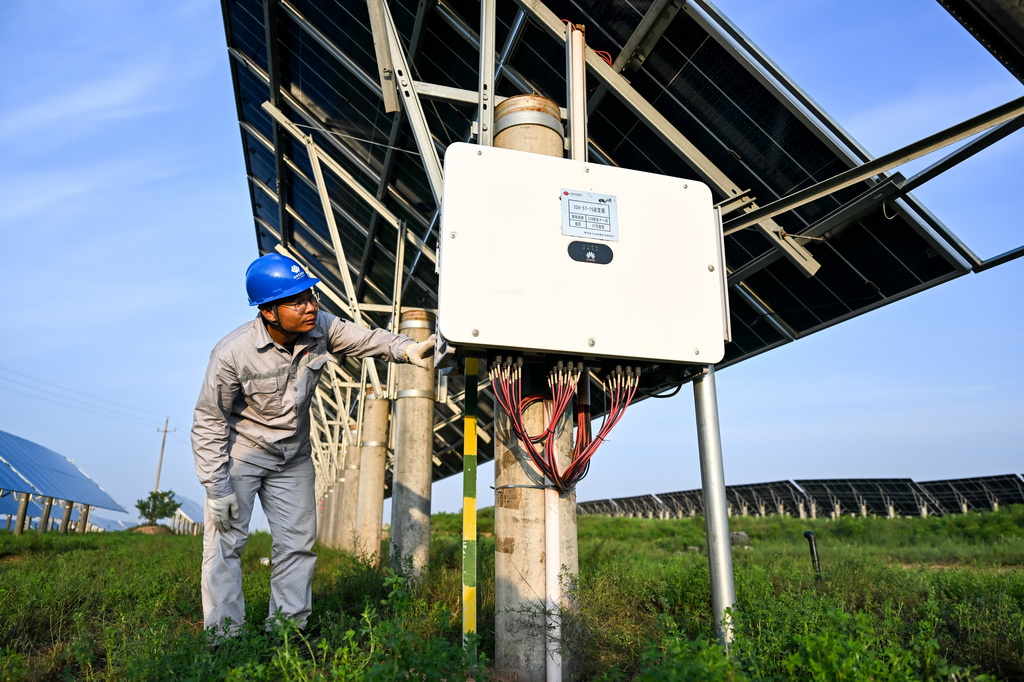 工人在天驕綠能50萬千瓦采煤沉陷區生態治理光伏發電示范項目區巡查光伏發電設備（7月30日攝）。