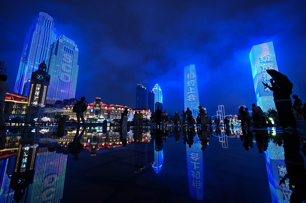 市民游客在雨中欣賞天津海河岸邊的夜景（8月24日攝）。新華社記者 趙子碩 攝