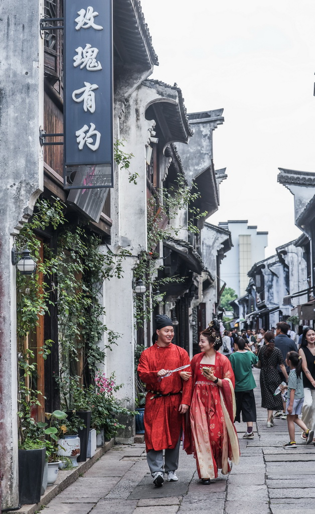 8月26日，在嘉興市南湖區月河歷史街區，游客身著傳統服飾在古巷中拍攝寫真。