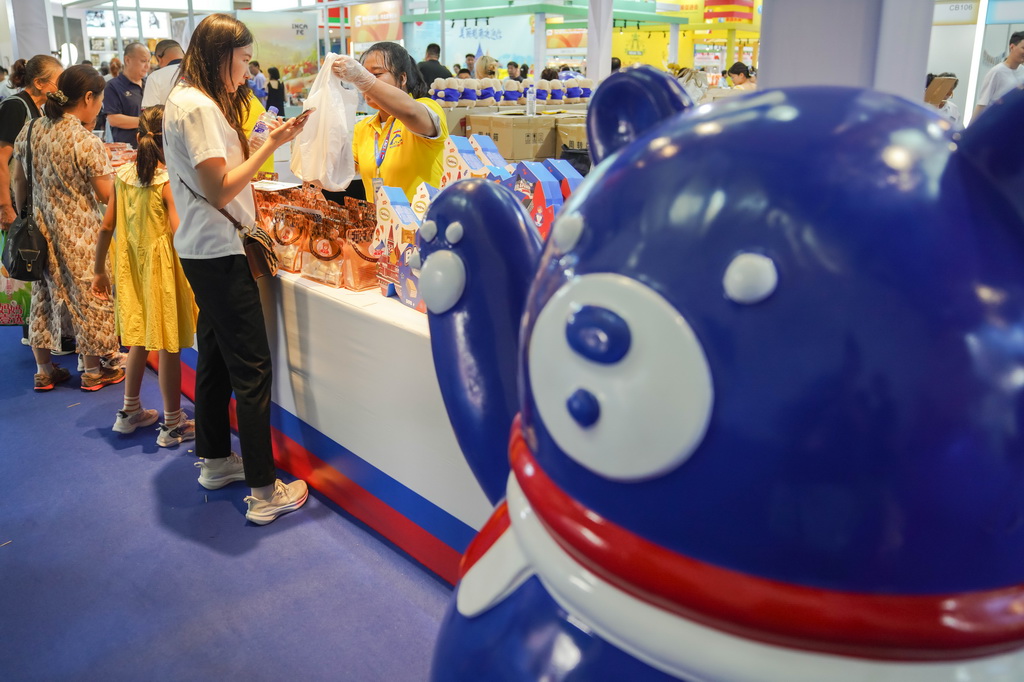 8月27日，游客在第十五屆中國－東北亞博覽會國際及港澳臺特色商品館內選購俄羅斯特色商品。新華社記者 許暢 攝