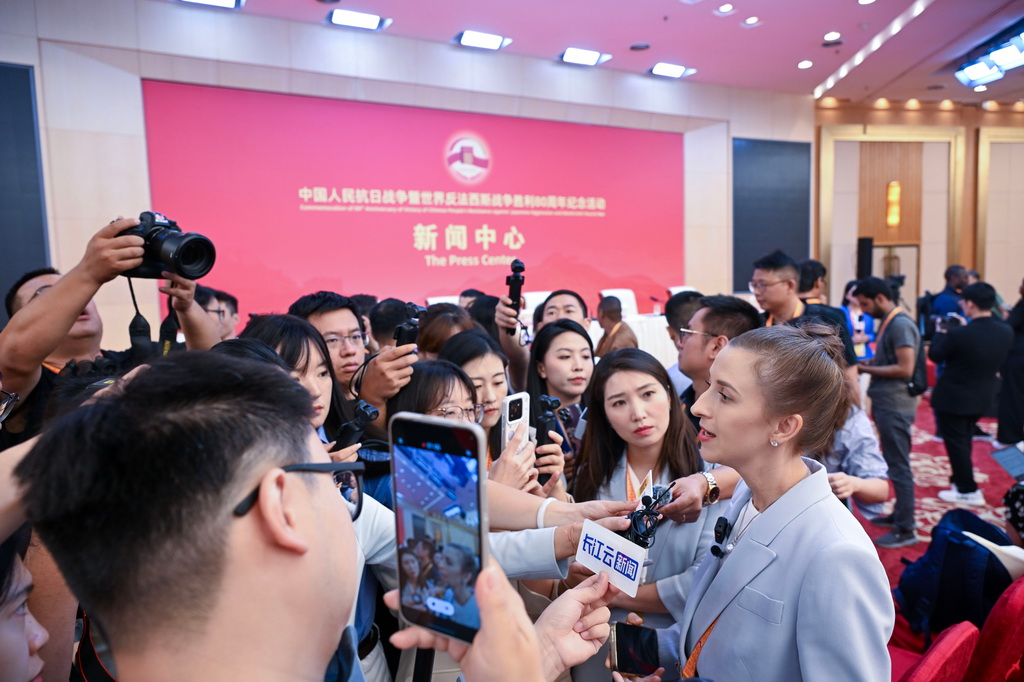 8月28日，記者在新聞中心采訪工作。