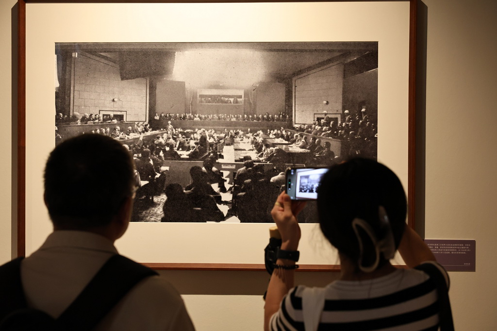9月1日，參觀者在藝術展上展出的抗戰主題攝影作品前駐足觀看。