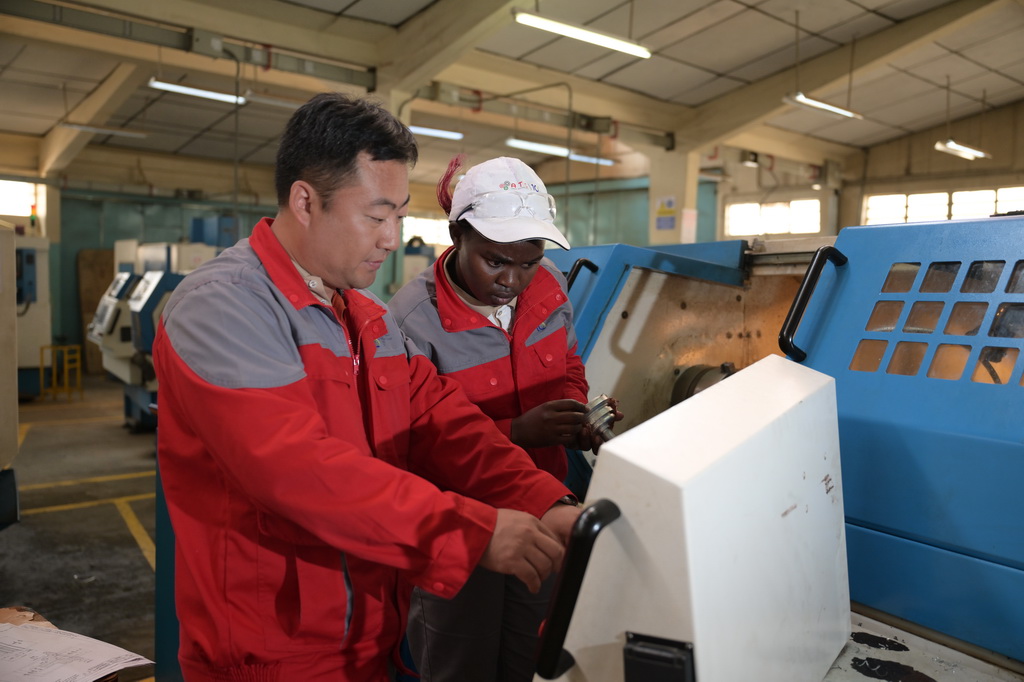 8月29日，在位于肯尼亞首都內羅畢的肯尼亞科技大學，中方指導老師與第十屆非洲職業技能挑戰賽的參賽選手在數控車床前交流。新華社記者 楊光 攝