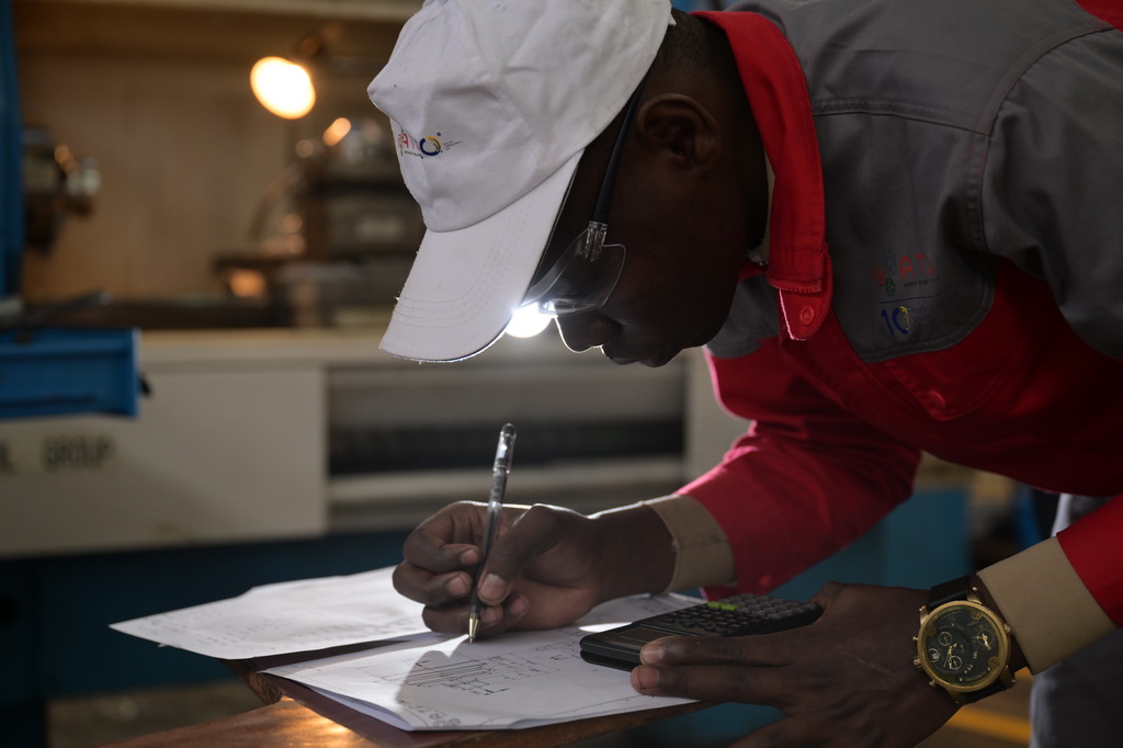 8月29日，在位于肯尼亞首都內羅畢的肯尼亞科技大學，一名第十屆非洲職業技能挑戰賽的參賽選手在數控機床前進行計算。新華社記者 楊光 攝