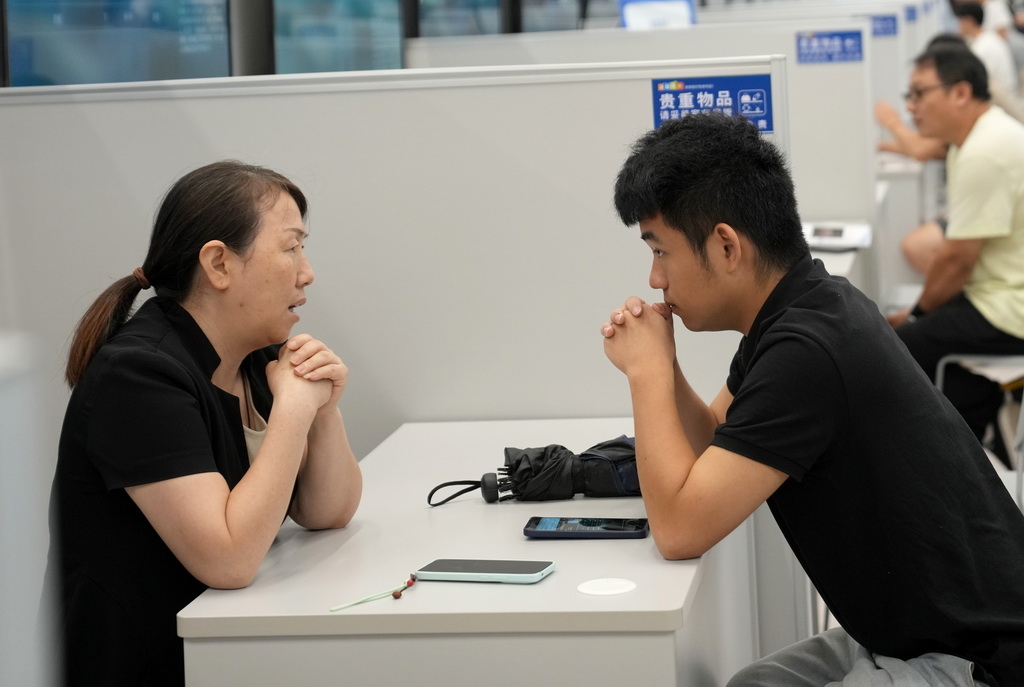 9月4日，一名求職者（右）與招聘企業代表在杭州市綜合性人才招聘會上洽談。
