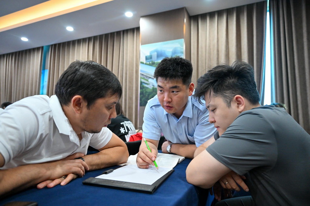 天津軌道交通集團培訓教師張垚（中）在培訓期間通過翻譯為哈薩克斯坦學員答疑（7月14日攝）。