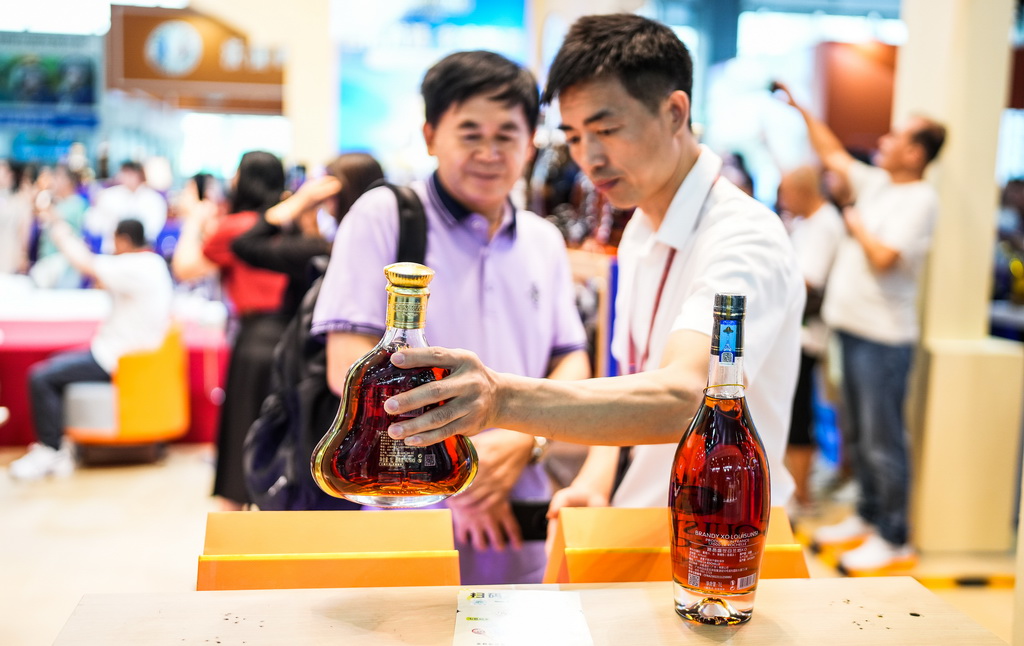 9月9日，參展商在酒博會現場向消費者推介酒類商品。