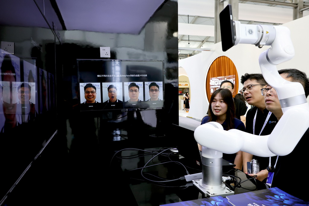 9月10日，參觀者在一個甄別AI換臉技術的演示設備前駐足觀看。