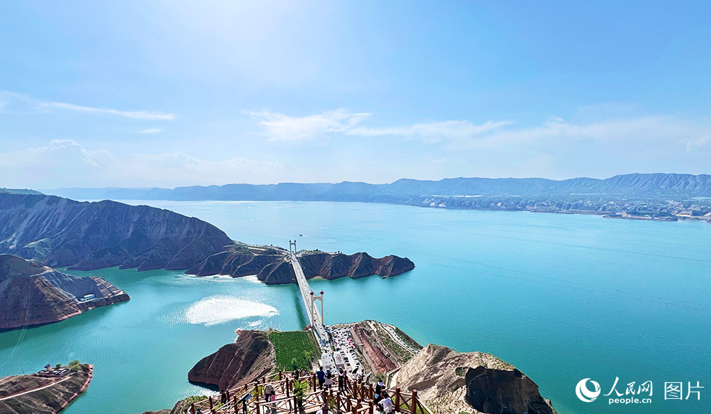 6月14日，甘肅省臨夏回族自治州永靖縣黃河段呈現出水色湛藍、平靜清澈的美麗景象。該區域匯集了大夏河、洮河等多條河流，并坐擁炳靈湖、太極湖和恐龍湖三大湖泊。近年來，永靖縣重點推進水環境治理，通過對黃河兩岸山體進行系統綠化，坡地逐步形成了以耐旱草本和灌木為主的完整植被生態系統，有效實現了水土保持。累計建成生態林24.73萬畝、經濟林9500畝，治理水土流失813平方公里。黃河臨夏段成功入選全國第三批美麗河湖優秀案例，并贏得了“藍色黃河”的美譽。人民網記者 焦隆攝