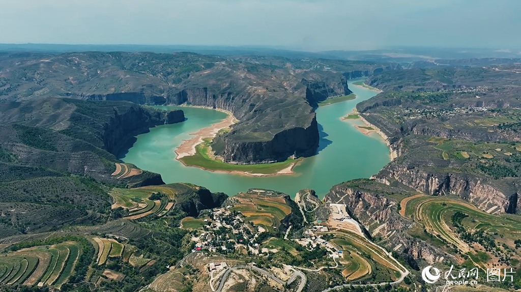 位于內蒙古呼和浩特市清水河縣老牛灣鎮的老牛灣黃河大峽谷，是黃河與長城唯一“握手”的地方，素有“天下黃河第一灣”的美譽。近年來，老牛灣鎮積極踐行“綠水青山就是金山銀山”的發展理念，以創建國家5A級旅游景區作為鄉村振興工作的重要抓手，推進文旅融合高質量發展。優美獨特的自然環境吸引了大量游客，今年“五一”峰值日客流量達2萬人，如今，運營民宿、游船等已成為當地村民實打實的優勢產業、特色產業、富民產業。人民網 孟佳澍攝