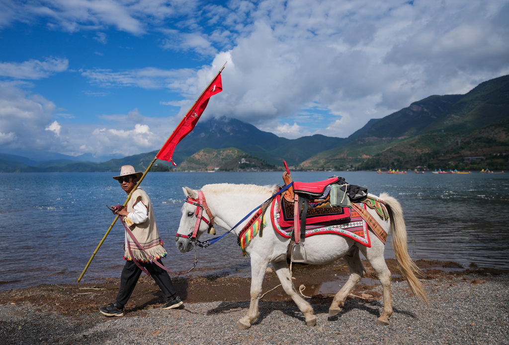 9月16日，一名當地男子趕著馬轉山。