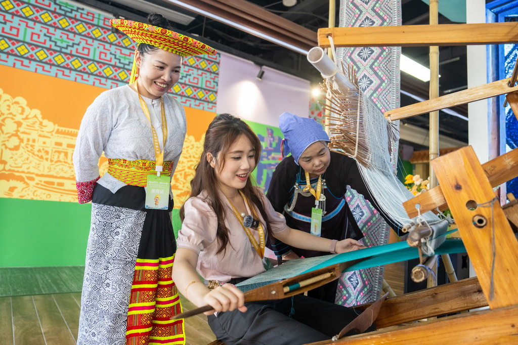 9月16日，在湖南省懷化市五溪非遺園，游客在體驗侗族織錦技藝。