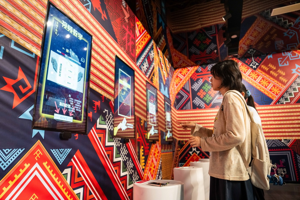 9月16日，在湖南省懷化市五溪非遺園，游客在體驗數字化花瑤挑花。