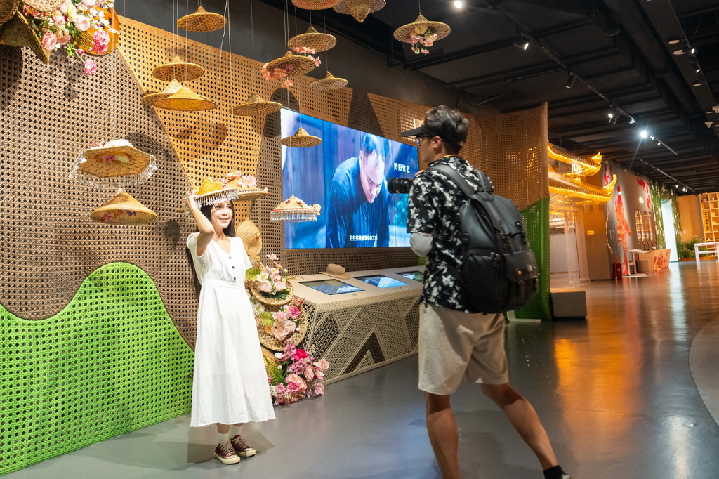 9月16日，在湖南省懷化市五溪非遺園，游客（左）在試戴黔陽竹藝編制的帽子。