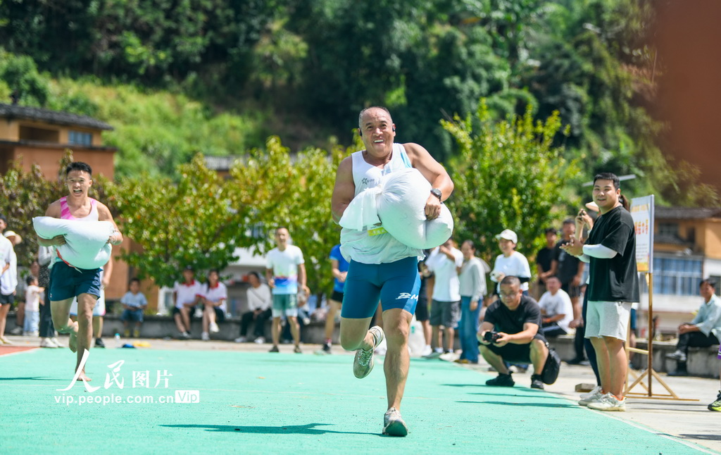 9月20日，貴州省黔西南布依族苗族自治州冊亨縣者樓街道高峰村，當地群眾在參加運糧接力比賽。