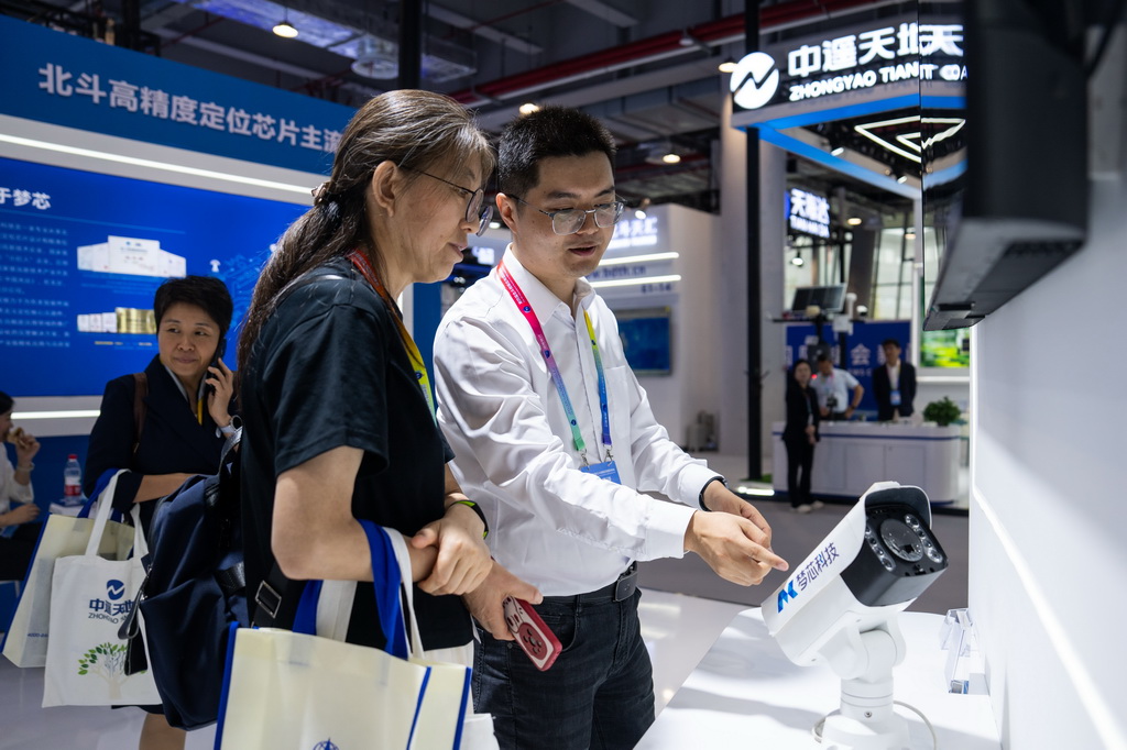 9月24日，在株洲國際會展中心，工作人員（右）在介紹一臺配有北斗技術的監控設備。