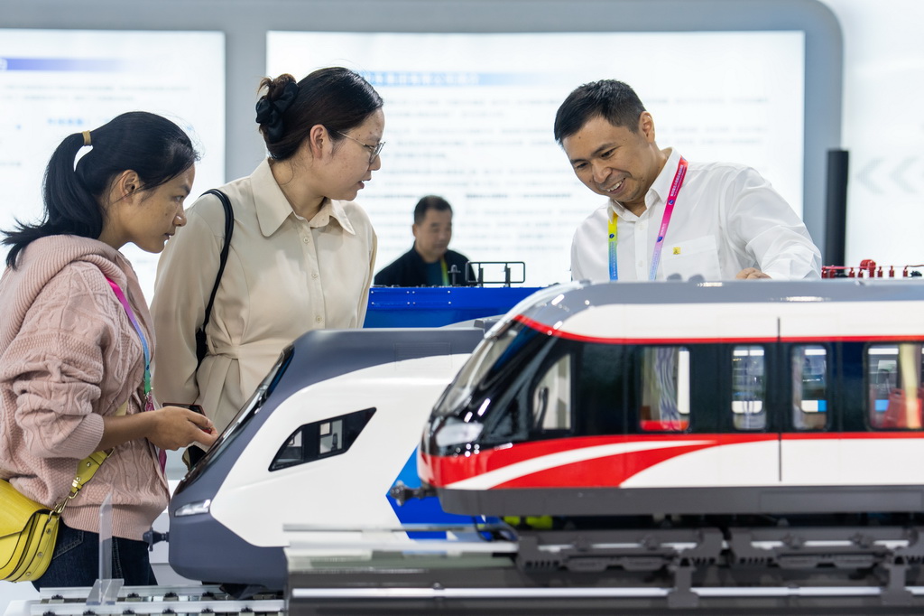 9月24日，在株洲國際會展中心，工作人員（右一）在介紹國產動車組列車。