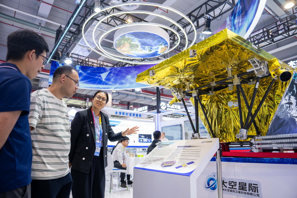 9月24日，在株洲國際會展中心，工作人員（左三）在介紹一臺對地觀測衛星。