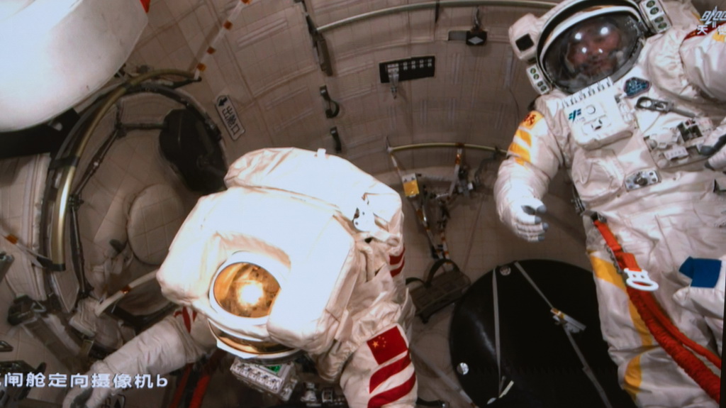 這是9月25日晚在北京航天飛行控制中心屏幕上拍攝的神舟二十號乘組航天員王杰（左）、陳中瑞在艙內工作的畫面。新華社記者 李明剛 攝