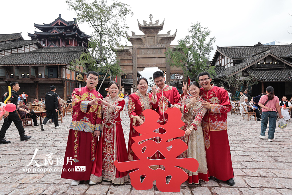 10月1日，在四川省宜賓市敘州區的宜賓長江公園，“宜見傾心·愛在宜賓——蜜月之旅長長久久·江江好”活動火熱舉行。26對新人舉行集體婚禮，乘坐雙層愛情巴士，開啟一場串聯城市地標、融合文旅風情的浪漫巡游。蘭鋒攝（人民圖片網）