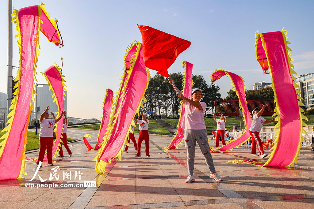 10月1日，山東青島西海岸新區市民廣場，西海岸龍舞隊的隊員們舞起彩龍，喜慶國慶佳節。韓加君攝（人民圖片網）