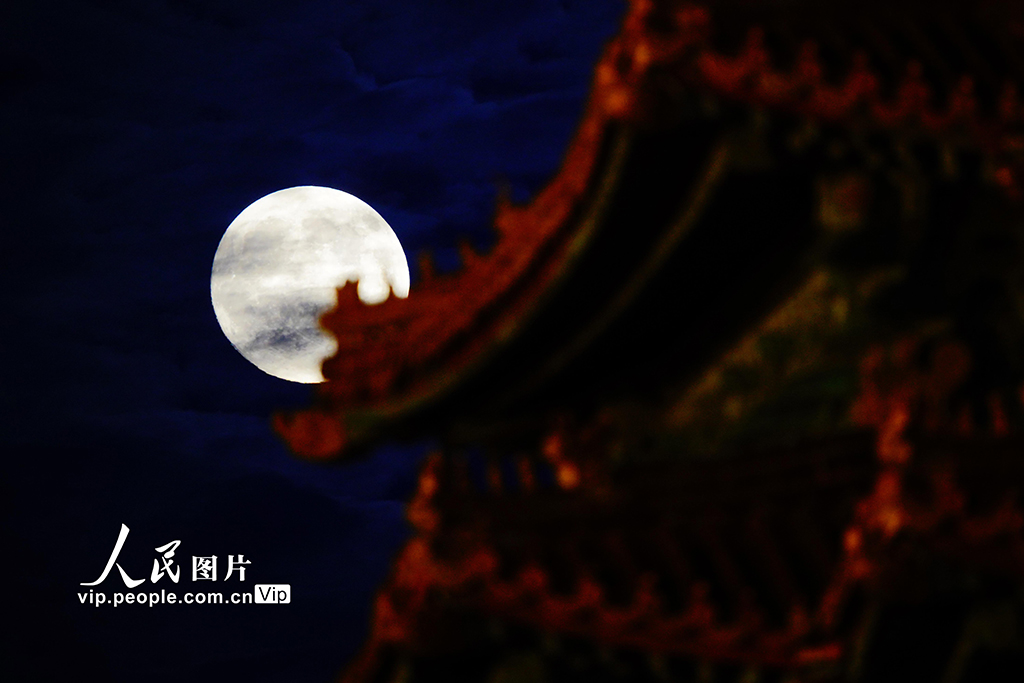 10月6日，一輪圓月現身夜空，與故宮角樓上的脊獸悄然同框。宋家儒攝（人民圖片網）