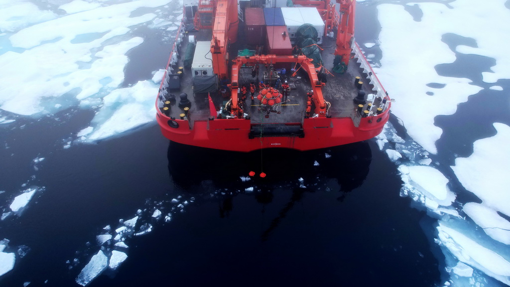 隊員們布放生態海底著陸器（Lander），當時海面上有很多海冰（無人機照片，2025年7月24日攝）。新華社記者 劉詩平 攝