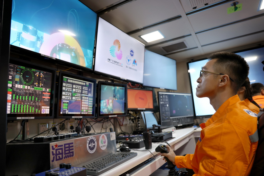 在科考船上的“海馬”號深海遙控潛水器控制室里，工作人員遙控采火裝置在海底進行作業（9月18日攝）。