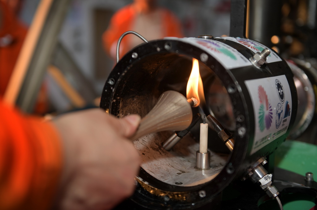 在科考船甲板面，工作人員從搭載在“海馬”號深海遙控潛水器上的采火裝置里取火（9月18日攝）。