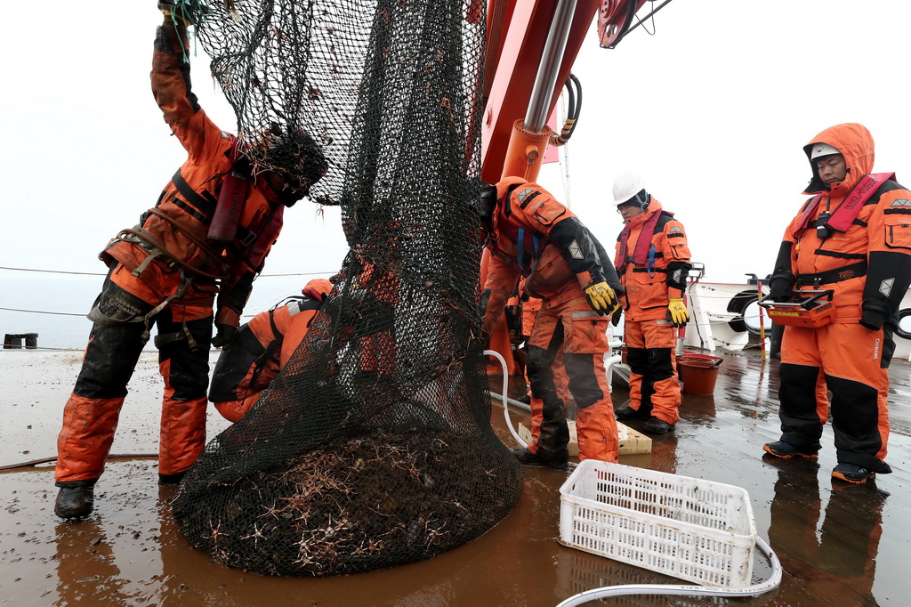 科考隊員在回收底拖網（2025年7月23日攝）。新華社記者 劉詩平 攝