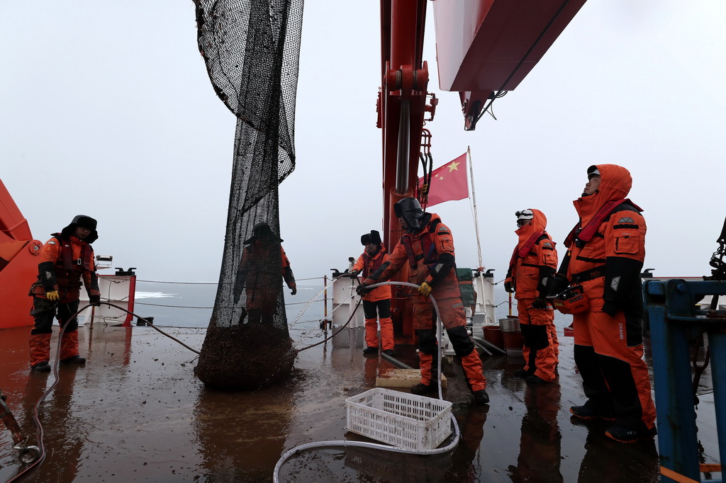 科考隊員在回收底拖網（2025年7月23日攝）。新華社記者 劉詩平 攝