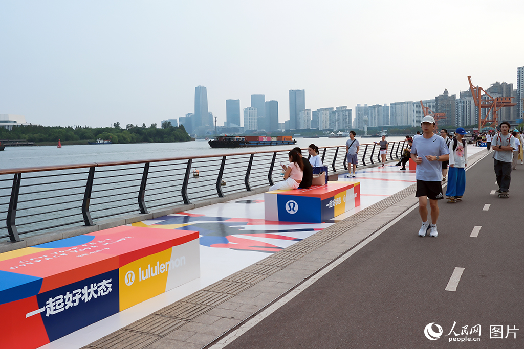 10月1日下午，上海市徐匯濱江綠地步道上，不少來滬游玩的游客和前來散步、跑步的附近居民在此享受國慶長假，愜意悠然。上海作為長江經濟帶的龍頭城市與核心引擎，徐匯濱江已成為上海濱江經濟發展的重要增長極。龍頭企業紛紛落戶，西岸中環商業集群加速形成，龍美術館等文化地標串聯藝術脈絡，共同為11.4公里濱江岸線注入持續活力。人民網記者 龔莎攝