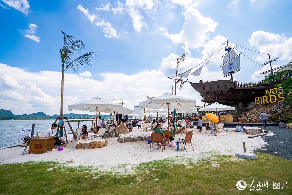 7月30日，位于貴州省貴陽市清鎮市的紅楓湖碧波蕩漾，20公里湖岸線蜿蜒舒展，與青山藍天相映成趣，前來“觀?！钡氖忻裼慰徒j繹不絕。近年來，當地立足紅楓湖生態稟賦，大力治理農村人居環境，一條環湖旅居產業示范帶正逐步成形。截至目前，清鎮市已培育鄉村旅游重點村17個、旅居民宿208家，同時衍生出露營基地、集裝箱小吃集市、特色咖啡店、非物質文化遺產體驗等多元業態。人民網記者 涂敏攝