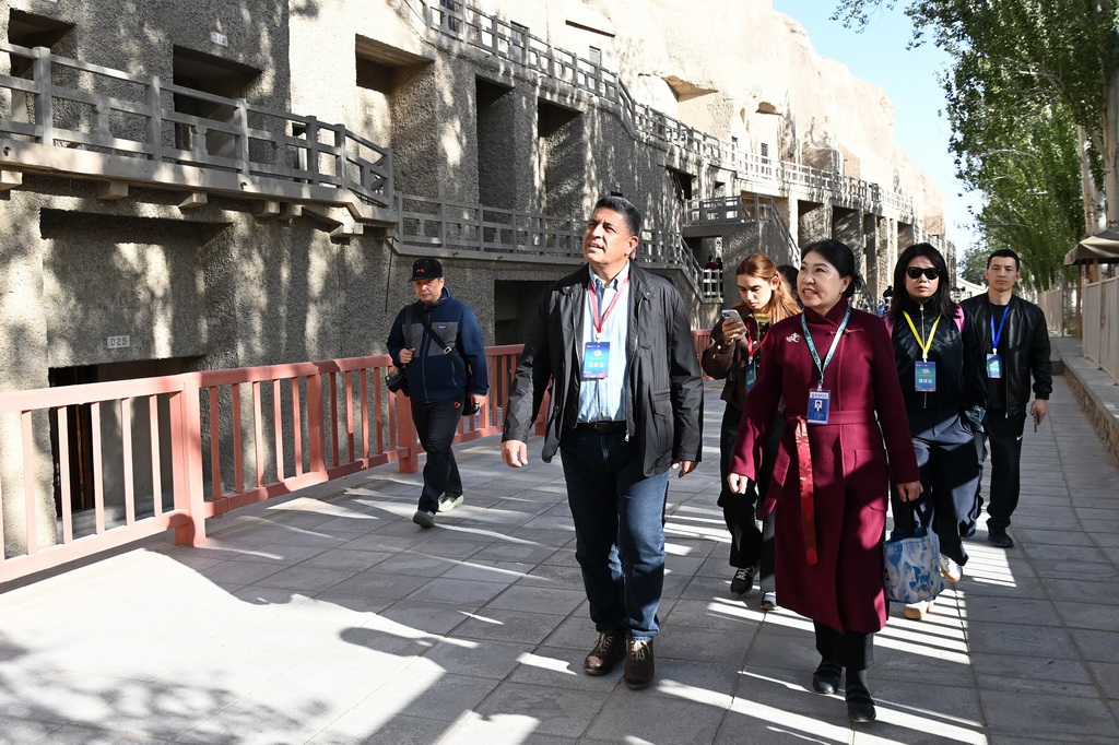 10月12日，外國嘉賓在敦煌莫高窟參觀。新華社記者 范培珅 攝
