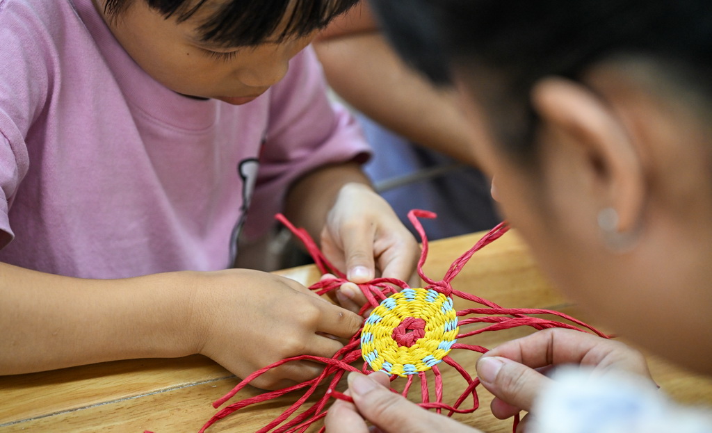 10月12日，在海南省文化館，小朋友學習東山草編技藝。