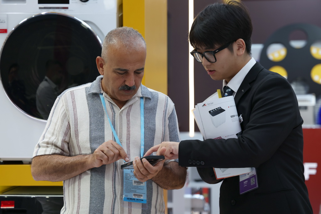  10月15日，客商在廣交會上洽談。