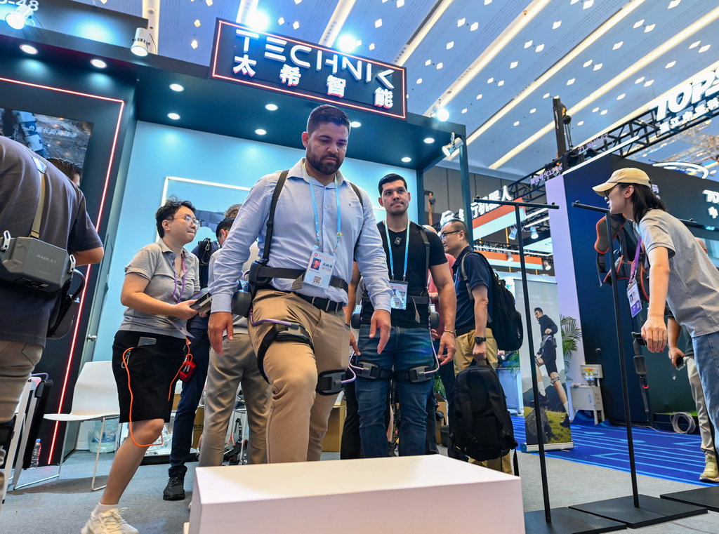 10月15日，境外采購商在第138屆廣交會服務機器人專區太希智能展臺體驗登山助行外骨骼穿戴設備。新華社記者 肖恩楠 攝