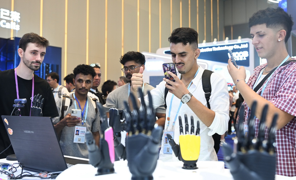 10月15日，境外采購商在第138屆廣交會服務機器人專區體驗機器手同步動作。新華社記者 鄧華 攝