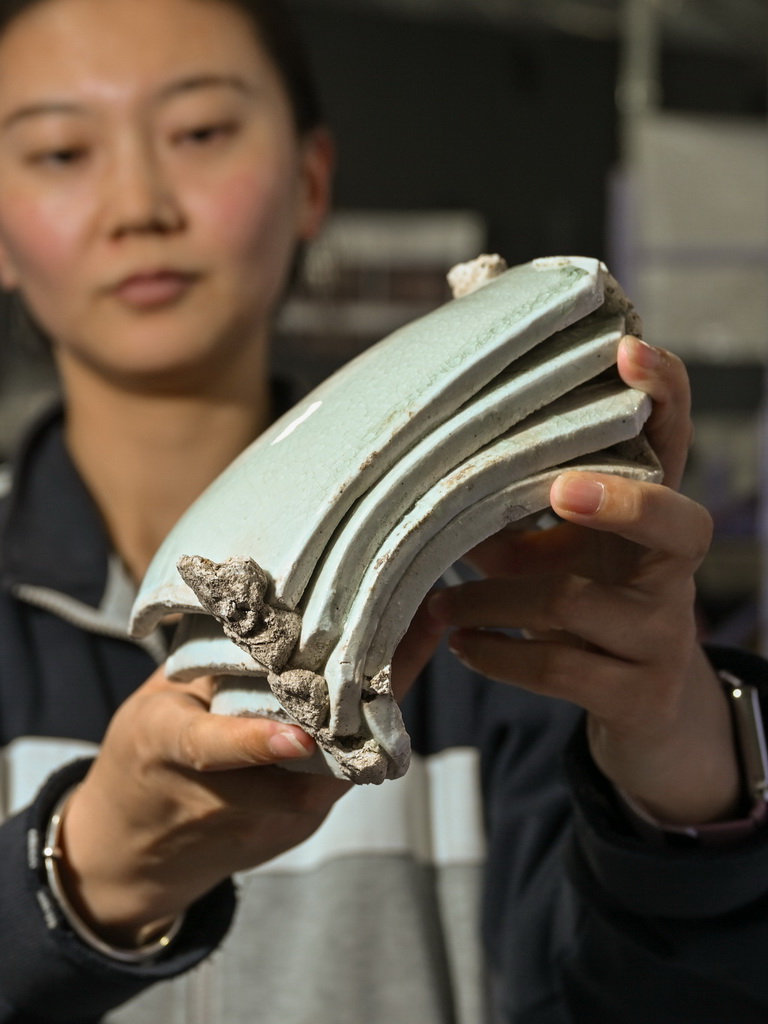 一位工作人員在蘇峪口瓷窯址考古隊文物庫房內展示發掘出土的白瓷板瓦標本（10月13日攝）。新華社記者 李賀 攝