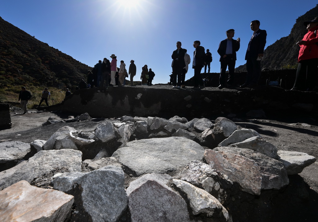 考古學家們在對蘇峪口瓷窯址2025年度發掘區出土的一處石英加工遺跡進行考察（10月13日攝）。新華社記者 李賀 攝