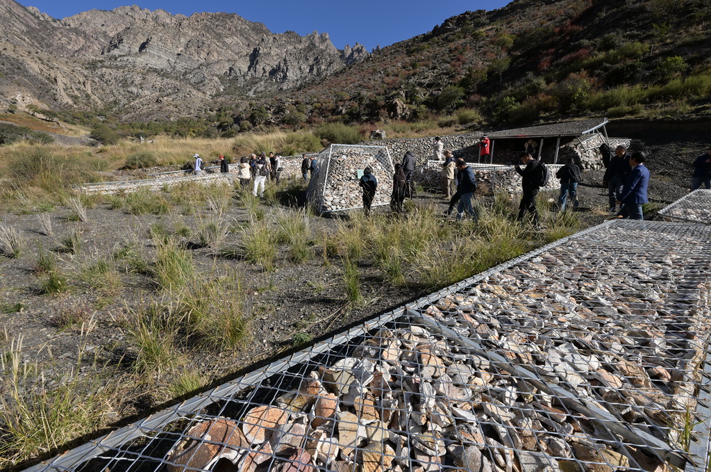 為更好保護和展示蘇峪口瓷窯遺址，考古隊工作人員使用牛毛氈和發掘出土的匣缽殘片以及鐵絲網將2021-2023年度發掘區遺跡進行了回填保護并原址展示（10月13日攝）。新華社記者 李賀 攝