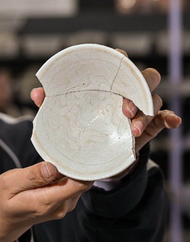 工作人員在蘇峪口瓷窯址考古隊文物庫房內展示發掘出土的帶有刻劃花紋的瓷器殘片（10月13日攝）。新華社記者 李賀 攝