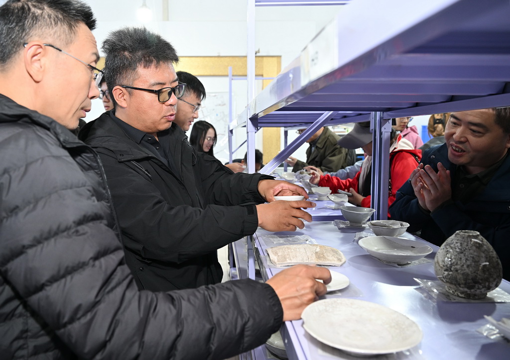 蘇峪口瓷窯址考古隊執行領隊柴平平（左二）在考古隊文物庫房內向前來考察的專家介紹出土瓷器情況（10月13日攝）。新華社記者 李賀 攝